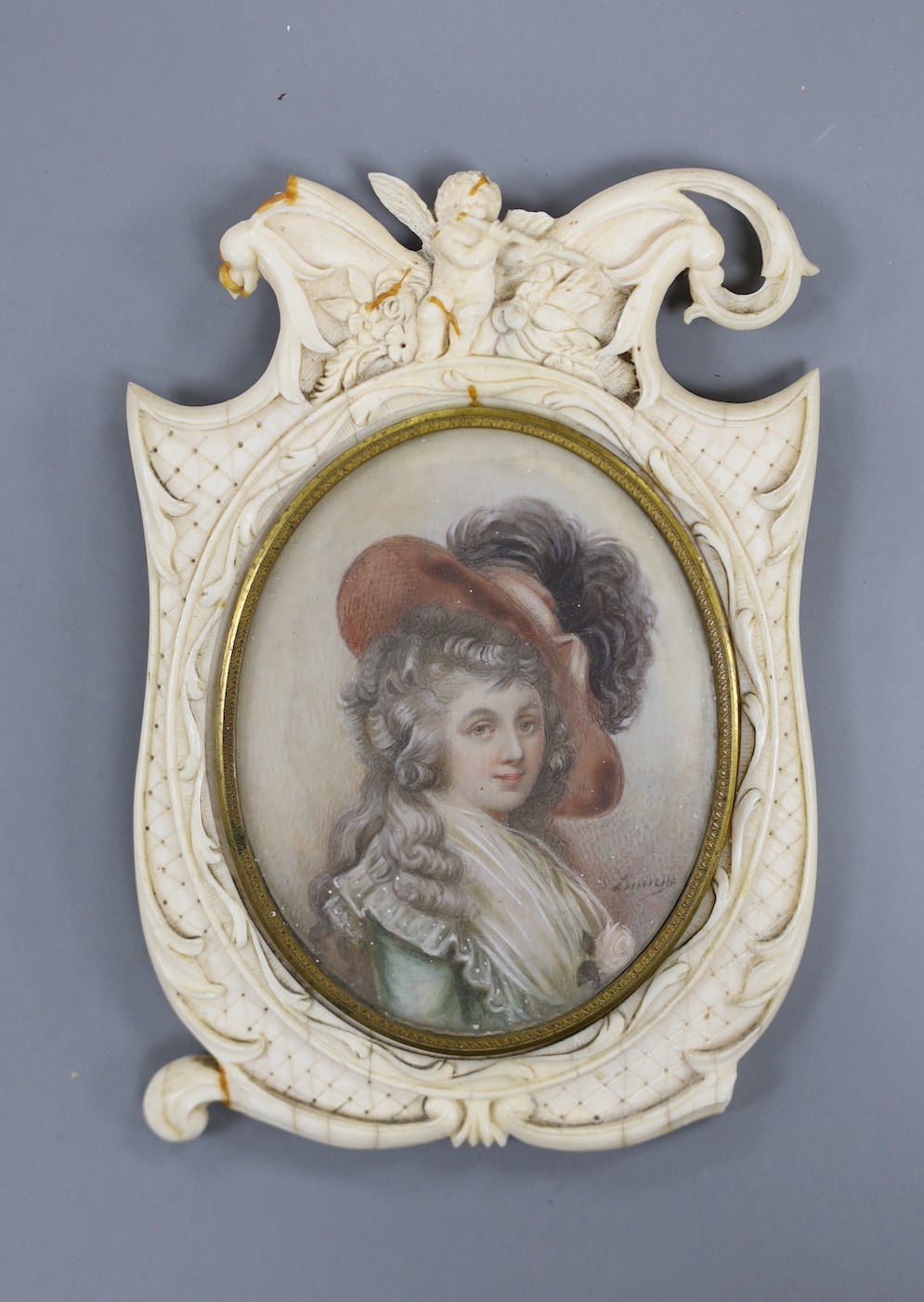 A 19th century carved ivory frame housing an indistinctly signed portrait miniature of a lady 14cm high.